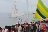 Warga menyaksikan lomba perahu layar tradisional di Desa Kayubura, Parigi Utara, Parigi Moutong, Sulawesi Tengah, Minggu (9/4). Lomba yang diikuti sedikitnya 40 peserta perahu layar itu untuk memeriahkan Feastival Pesona Teluk Tomini (FPTT) 2017. ANTARA FOTO/Fiqman Sunadar/wdy/17.