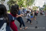 Sejumlah pengunjung memainkan tarik tambang pada saat Car Free Day di Tunjungan, Surabaya, Jawa Timur, Minggu (9/4). Kegiatan rutin yang bertajuk 'Ayo Rek Dolanan' bertujukan memberikan pembelajaran diluar sekolah menggunakan media boneka, permainan tradisional dan juga diskusi. Antara Jatim/Naufal Ammar/SHP/17.
