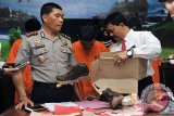 Wakil Kapolresta Denpasar AKBP Nyoman Artana (kiri) bersama Kasat Narkoba Polresta Denpasar Kompol I Gede Ganefo (kanan) memeriksa tersangka pengedar narkoba di Mapolresta Denpasar, Senin (10/4). Polisi menangkap empat pengedar narkoba yang diduga dikendalikan oleh narapidana di Lembaga Pemasyarakatan (Lapas) Kerobokan, Bali dengan barang bukti 19 paket sabu-sabu dari Bogor yang disembunyikan dalam paket kiriman sepatu. FOTO ANTARA/Nyoman Budhiana/i018/2017.