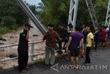 Sejumlah warga mencari pelajar Madrasah Tsanawiyah yang hanyut di Sungai Catur dari atas jembatan di Kabupaten Madiun, Jawa Timur, Senin (10/4). Sebanyak enam pelajar Madrasah Tsanawiyah asal Magetan yang mengikuti kegiatan outbond hanyut di sungai saat mendadak banjir. Antara Jatim/Siswowidodo/zk/17