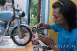 Perajin menyelesaikan miniatur motor kuno di Kemlaten, Surabaya, Jawa Timur, Rabu (12/4). Kerajinan yang terbuat dari aluminium tersebut dijual seharga Rp300 ribu- Rp400 ribu tergantung tingkat kesulitannya. Antara Jatim/Naufal Ammar/zk/17.
