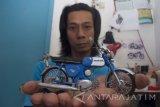 Perajin menunjukkan miniatur motor kuno di Kemlaten, Surabaya, Jawa Timur, Rabu (12/4). Kerajinan yang terbuat dari aluminium tersebut dijual seharga Rp300 ribu- Rp400 ribu tergantung tingkat kesulitannya. Antara Jatim/Naufal Ammar/zk/17.