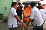 Petugas mengusung jenazah pelajar Madrasah Tsanawiyah yang ditemukan di sungai Desa Prambon, Dagangan, Kabupaten Madiun untuk dilakukan identifikasi di kamar mayat RSUP dr Soedono Madiun, Jawa Timur, Rabu (12/4). Jenazah tersebut merupakan satu dari enam pelajar Madrasah Tsanawiyah asal Magetan yang mengikuti kegiatan outbond di Wana Wisata Grape dan hanyut di sungai saat mendadak banjir pada Senin (10/4). Antara Jatim/Foto/Siswowidodo/zk/17