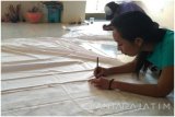 Seorang pekerja membuat desain di Rumah Batik, Jalan Putat Jaya, Surabaya, Selasa (11/4). Kawasan prostitusi Dolly di daerah Putat Jaya kini telah berubah menjadi kawasan ekonomi dengan berbagai aktivitas usaha, salah satunya membuat batik. (Antara Jatim/Putri/SHP/17)