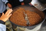 Petani menunggu hasil kopi pascadimasak di mesin untuk memasak kopi di Desa Geger, Kecamatan Sendang, Kabupaten Tulungagung, Jawa Timur, Rabu (12/4). Petani di Kecamatan Sendang mendapatkan bantuan mesin pengolah kopi. Kapasitas mesin itu bisa menggoreng hingga 3 kilogram dengan menggunakan bahan bakar elpiji, sehingga bisa membantu petani untuk lebih mempercepat proses produksi. Antara Jatim/Foto/Asmaul Chusna/zk/17