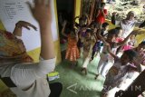 Relawan menghibur anak-anak terdampak longsor di pos layanan dukungan psikososial bantuan dari Kementerian Sosial di Desa Ngetos, Nganjuk, Jawa Timur, Kamis (13/4). Terapi melalui skema trauma healing dilakukan relawan bencana guna memulihkan psikologi anak dari trauma bencana yang mereka alami di lingkungan tempat tinggal mereka. Antara Jatim/Prasetia Fauzani/zk/17 