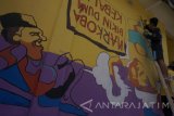 Warga dan anggota pramuka membuat lukisan mural di tembok rumah warga di Kelurahan Ngantru, Trenggalek, Jawa Timur, Jumat (14/4). Kegiatan yang dikemas dalam program kampung kelir di 11 kabipaten/kota se-Jatim dengan tema 'warna-warni itu indah' tersebut melibatkan sedikitnya 1.000 anggota pramuka dari berbagai daerah dengan tujuan kampanye  kawasan pemukiman yang bersih aman dan sehat (BAS) ssekaligus sebagai destinasi wisata baru. Antara Jatim/Destyan Sujarwoko/zk/17