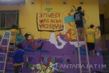 Warga dan anggota pramuka membuat lukisan mural di tembok rumah warga di Kelurahan Ngantru, Trenggalek, Jawa Timur, Jumat (14/4). Kegiatan yang dikemas dalam program kampung kelir di 11 kabipaten/kota se-Jatim dengan tema 'warna-warni itu indah' tersebut melibatkan sedikitnya 1.000 anggota pramuka dari berbagai daerah dengan tujuan kampanye  kawasan pemukiman yang bersih aman dan sehat (BAS) ssekaligus sebagai destinasi wisata baru. Antara Jatim/Destyan Sujarwoko/zk/17