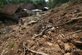 Sejumlah warga berada di sekitar rumah yang rusak terkena longsor di Desa Surat, Kecamatan Mojo, Kediri, Jawa Timur, Senin (17/4). Bencana alam di lereng gunung Wilis pada Kamis (6/4) terebut mengakibatkan sejumlah warga yang menempati 6 rumah terdampak longsor terpaksa masih mengungsi di rumah kerabat atau tetangga karena adanya potensi terjadi longsor susulan. Antara Jatim/Prasetia Fauzani/zk/17