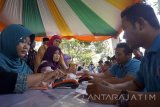 Menteri Sosial Khofifah Indar Parawansa (ketiga kiri) melihat proses pencairan program keluarga harapan (PKH) tahap IV di Trenggalek, Jawa Timur, Selasa (18/4). Pemerintah menggandeng himpunan empat bank negara (Himbara) yang terdiri dari BNI, BRI, Bank Mandiri dan BTN untuk menyalurkan bantuan PKH nontunai ke 6 juta KPM (kelompok penerima manfaat) di seluruh Indonesia dengan total subsidi kesejahteraan rakyat sebesar Rp11,4 triliun. Antara Jatim/Destyan Sujarwoko/zk/17