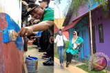 Wali Kota Banjarbaru H Nadji Adhani bersama Wakil Wali Kota   Banjarbaru Darmawan Jaya Setiawan melalukan pengecatan pada salah satu dinding rumah warga dalam program Kampung Pelang (kanan), istri Wali Kota Banjarbaru menikmati suasana kampung pelangi (kiri) di kawasan Sungai Kemuning Banjarbaru, Sabtu (15/4).(Foto Antaranews Kalsel/uviek/F)