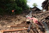 Petugas Badan Penanggulangan Bencana Daerah (BPBD) melihat reruntuhan rumah di kawasan longsor Desa Banaran, Pulung, Ponorogo, Jawa Timur, Kamis (20/4). Luapan sungai yang membawa material longsoran bukit mengakibatkan sebuah rumah hanyut dan dua rumah roboh. Antara Jatim/Siswowidodo/zk/17