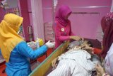 Petugas medis melayani pasien di instalasi 'red-zone' kegawatdaruratan RSUD dr Iskak, Tulungagung, Jawa Timur, Jumat (21/4). Seluruh tenaga dokter dan perawat perempuan di RSUD dr Iskak mengenakan kostum kebaya atau adat Jawa dalam rangka memperingati hari lahir Pahlawan Nasional RA Kartini, 21 April. Antara Jatim/Destyan Sujarwoko/zk/17