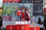 Juara Banyuwangi International BMX Elga Kharisma Novanda (tengah) dari Timnas Indonesia bersama Juara kedua Cupi Novianti (kiri) Timnas Indonesia, dan juara ketiga Tifania Adine (kanan) Factory Team Indonesia naik podium menerima penyerahan piala di Sirkuit BMX Muncar, Banyuwangi, Jawa Timur, Minggu (23/4). Elga Kharisma berhasil mempertahankan gelar juara kategori Women Elit setelah berhasil finis tercepat mengalahkan rivalnya. Antara Jatim/Budi Candra Setya/zk/17.