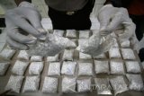 Petugas kepolisian menunjukan barang bukti pil koplo sebanyak 44.000 butir saat gelar perkara penyalah gunaan narkoba di Polres Kediri, Jawa Timur, Kamis (27/4). Pil koplo tersebut diamankan dari dua orang tersangka pengedarnya berinisial AA dan MJ yang mengaku mereka dapatkan dari seseorang di daerah Surabaya seharga Rp300.000 per seribu butir. Antara Jatim/Prasetia Fauzani/zk/17