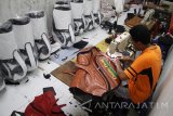 Pekerja menyelesaikan pembuatan tas golf di industri rumahan kawasan Tanggulangin, Sidoarjo, Jawa Timur, Sabtu (29/4). Menurut Pengrajin, Tas golf yang dijual dengan harga Rp2.3 juta-Rp5.5 juta dan dikirim ke berbagi kota besar seperti Jakarta, Yogyakarta, Surabaya, Bandung hingga tembus pasar ekspor di Jerman, Dubai serta Malaysia tersebut terkendala dengan banyaknya permintaan namun tenaga untuk membuatnya terbatas. Antara Jatim/Umarul Faruq/zk/17