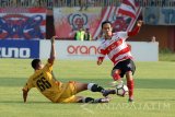 Pesepak boila Madura United (MU) FC, Slamet Nur Cahyo (kanan) berebut bola dengan pesepak bola Mitra Kukar, Dhika Pratama Putra (kiri bawah)  dalam Kompetisi Gojek Traveloka Liga 1 di Stadion Gelora Ratu Pamelingan (SGRP) Pamekasan, Jumat (28/4). Mitra Kukar berhasil menahan MUFC denngan skor 2-2. Antara Jatim/Saiful Bahri/zk/17