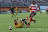 Pesepak boila Madura United (MU) FC, Odem Piter Wingie (kanan) melewati hadangan pesepak bola Mitra Kukukar, Dhika Pratama Putra (kiri bawah)  dalam Kompetisi Gojek Traveloka Liga 1 di Stadion Gelora Ratu Pamelingan (SGRP) Pamekasan, Jumat (28/4). Mitra Kukar berhasil menahan MUFC denngan skor 2-2. Antara Jatim/Saiful Bahri/zk/17