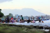 Wisatawan bermain di pantai Bangsring Underwater di Banyuwangi, Jawa Timur, Minggu (30/4).  Kunjungan wisatawan dikawasan konservasi tersebut, saat memasuki musim libur panjang meningkat hingga 1570 pengunjung dibandingkan hari biasanya sekitar 700 wisatawan. Antara Jatim/Budi Candra Setya/zk/17.