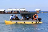 Wisatawan menaiki perahu menuju rumah apung di pantai Bangsring Underwater, Banyuwangi, Jawa Timur, Minggu (30/4). Kunjungan wisatawan dikawasan konservasi tersebut, saat memasuki musim libur panjang meningkat hingga 1570 pengunjung dibandingkan hari biasanya sekitar 700 wisatawan. Antara Jatim/Budi Candra Setya/zk/17.