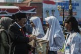 Gubernur Jawa Timur Soekarwo (kedua kiri) memberikan penghargaan kepada siswa berprestasi pada upacara Hari Pendidikan Nasional 2017 di Gedung Negara Grahadi, Surabaya, Jawa Timur, Selasa (2/5). Upacara tersebut diselenggarakan untuk memperingati Hari Pendidikan Nasional 2017 dengan tema 'Percepat Pendidikan Merata dan Berkualitas sesuai dengan isi naskah pidato dari Menteri Pendidikan dan Kebudayaan. Antara Jatim/Naufal Ammar/zk/17.
