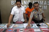 Kabid Humas Polda Jatim, Kombes Pol Frans Barung Mangera (kanan) Kasubdit Reknata IV Direskrimum Polda Jatim, AKBP Rama Samtama Putra (kiri) menunjukkan barang bukti tersangka kasus prostitusi online di kantor Bidang Humas Mapolda Jatim, Surabaya, Jawa Timur, Selasa (2/5). Direktorat Reserse dan Kriminal Umum (Ditreskrimum) Polda Jatim berhasil mengamankan tersangka penyedia jasa prostitusi online dengan barang bukti uang tunai sejumlah Rp1.9 juta, dan sejumlah lembar foto  para perempuan. Antara Jatim/Umarul Faruq/zk/17