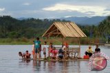 Pengunjung menggunakan jasa rakit untuk berkeliling di objek wisata alam Danau Perintis, Kabupaten Bone Bolango, Gorontalo. Pemerintah Kabupaten Bone Bolango terus meningkatkan promosi dan pengembangan pariwisata alam untuk memikat wisatawan domestik maupun mancanegara. (ANTARA FOTO/Adiwinata Solihin)