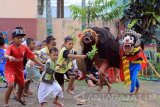 Sejumlah anak memainkan kesenian tradisional barong di Licin, Banyuwangi, Jawa Timur, Sabtu (6/5). Kegiatan tersebut rutin dilakukan anak-anak diluar jam sekolah untuk mengisi waktu luang dengan belajar kesenian daerahnya. Antara Jatim/Budi Candra Setya/zk/17.