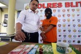 Polisi menunjukkan tersangka beserta sejumlah alat bukti saat rilis kasus penipuan berkedok dukun pengganda uang di Mapolres Blitar, Jawa Timur, Selasa (9/5). Setelah sempat menjadi buron selama setahun, polisi akhirnya berhasil membekuk tersangka penipuan berkedok dukun pengganda uang beserta sisa uang jutaan rupiah dan barang bukti lainnya yang merupakan hasil kejahatannya. Antara Jatim/Irfan Anshori/zk/17