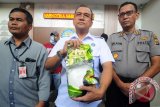 Kepala BNN provinsi Aceh, Brigjen Pol Eldi Azwar (tengah) didampingi Kapolresta Banda Aceh, Kombes Pol T Saladin (kanan) memperlihatkan barang bukti tindak kejahatan narkotika jenis sabu seberat satu kilogram saat gelar perkara di Banda Aceh, Selasa (9/5). BNN Aceh berhasil menangkap narapidana yang sudah tujuh bulan bebas di luar Lembaga Permasyarakatan kelas II A Banda Aceh saat melakukan transaksi narkotika jenis sabu di salah satu rumah makan wilayah kabupaten Aceh Besar, Aceh.  (ANTARA Aceh/Ampelsa)