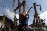 Peserta membawa orang-orangan sawah dalam Kirab Festival Kampung Tani di Temas, Batu, Jawa Timur, Jumat (12/5). Kegiatan yang bertujuan membangkitkan kembali semangat gotong-royong untuk memacu pertumbuhan ekonomi pariwisata melalui sektor pertanian tersebut diikuti ratusan peserta dengan menampilkan berbagai kreatifitas antara lain seni instalasi orang-orangan sawah, patrol kentongan dan permainan tradisional. Antara Jatim/Ari Bowo Sucipto/zk/17.