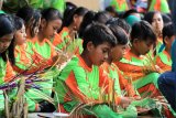 Sejumlah anak-anak mengikuti kegiatan menganyam bambu bersama-sama disepanjang jalan Desa Gintangan, Banyuwangi, Jawa Timur, Jumat (12/5). Kegiatan tersebut bagian dari agenda Banyuwangi Festival 2017 untuk mengangkat potensi kerajinan bambu di daerah itu. Antara Jatim/Budi Candra Setya/zk/17.