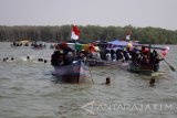 Puluhan perahu berlayar menuju laut saat tradisi Petik Laut warga Desa Cemandi, Sedati, Sidoarjo, Jawa Timur, Minggu (14/5). Tradisi petik laut yang diikuti nelayan setempat tersebut sebagai wujud rasa syukur atas berkah laut yang diterima. Antara Jatim/Umarul Faruq/zk/17