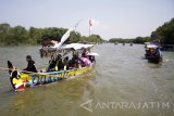 Puluhan perahu berlayar menuju laut saat tradisi Petik Laut warga Desa Cemandi, Sedati, Sidoarjo, Jawa Timur, Minggu (14/5). Tradisi petik laut yang diikuti nelayan setempat tersebut sebagai wujud rasa syukur atas berkah laut yang diterima. Antara Jatim/Umarul Faruq/zk/17