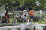Sejumlah anak bermain layangan di kompleks Taman Pemakamam Umum (TPU) Rangkah, Surabaya, Jawa Timur, Selasa (16/5). TPU tersebut dimanfaatkan untuk bermain bagi anak yang tinggal di sekitar pemakaman itu karena minimnya lahan bermain. Antara Jatim/Moch Asim/zk/17