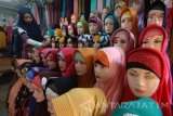 Pedagang menunggui hijab dagangannya di Pasar Kolpajung, Pamekasan, Jawa Timur, Jumat (19/5). Menjelang bulan ramadan permintaan busana muslim  meningka dibanding bulan-bulan sebelumnyat. Antara Jatim/Saiful Bahri/zk/17
