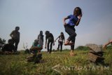 Seorang anak bermain 'Biseokchigi' yang berasal dari Korea Selatan saat acara pertukaran budaya permainan tradisional Indonesia, Korea Selatan dan Malaysia di Surabaya, Jawa Timur, Minggu (21/5). Kegiatan yang digagas oleh Komunitas Kampoeng Dolanan Surabaya tersebut bertujuan untuk mengenalkan bermacam jenis permainan tradisional sebagai khazanah budaya masing-masing negara. Antara jatim/Moch Asim/zk/17