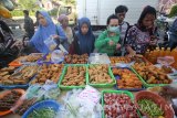 Pedagang melayani pembeli makanan untuk hidangan buka puasa (takjil) di kawasan Masjid Ampel, Surabaya, Jawa Timur, Sabtu (27/5). Selama bulan Ramadan, kawasan wisata religi Masjid dan Makam Sunan Ampel tersebut menjadi salah satu pusat pasar penjualan takjil. Antara Jatim/Moch Asim/zk/17