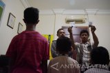 Polisi menunjukkan barang bukti batu di depan dua orang anak pelaku pelemparan Kereta Api (KA), Ade (kiri membelakangi kamera) dan Wahyu (kedua kiri membelakangi kamera) di Mapolsek Madiun, Kabupaten Madiun, Jawa Timur, Sabtu (27/5). Saat bermain dengan teman-temannya, kedua orang anak tersebut melakukan pelemparan KA Kahuripan jurusan Bandung-Blitar saat melintas di dekat Stasiun Babadan Madiun dan berhasil ditangkap petugas reaksi cepat PT KAI tak lama setelah pelemparan yang mengakibatkan kaca KA pecah. Antara Jatim/Siswowidodo/zk/17