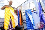 Syafril Pink memperlihatkan Celana Sarung Corak Insang OmPink rancangannya yang dijual di bazar ramadhan di Pontianak, Kalbar, Senin (29/5). Celana sarung yang dibuat dari kain bermotifkan Corak Insang khas Pontianak tersebut, dijual seharga Rp165 ribu hingga Rp185 ribu per buah sesuai ukuran. ANTARA FOTO/Jessica Helena Wuysang/17
