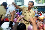 Seorang pegawai Pemerintah Kota Pontianak mengulurkan bungkusan berisi Bawang Putih yang dijual kepada masyarakat saat gelar pasar murah di Pasar Flamboyan, Pontianak, Kalbar, Selasa (30/5). Guna menstabilkan harga Bawang Putih yang telah mencapai Rp100 Ribu per kilogram, Kementerian Perdagangan bersama Kementerian Pertanian dan Pemerintah Kota Pontianak mendistribusikan 60-100 Ton Bawang Putih yang dijual ke masyarakat seharga Rp30 Ribu per kilogram. ANTARA FOTO/Jessica Helena Wuysang/17
