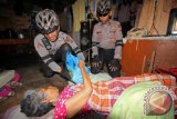 Personel Sabhara patroli sepeda Polres Lhokseumawe menyerahkan bantuan beras dan paket bahan pangan kepada warga kurang mampu di Desa Pusong, Lhokseumawe, Aceh, Jumat (2/6). Pemberian bantuan paket Ramadan bagi warga kurang mampu yang ditemui dalam patroli sepeda itu sebagai bentuk kepedulian polisi meringankan beban masyarakat kurang mampu selama menjalankan ibadah Ramadhan. (ANTARA FOTO/Rahmad)