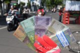Penjual jasa penukaran uang asal Semarang Jawa Tengah menawarkan uang baru kepada pengguna jalan di Kota Madiun, Jawa Timur, Minggu (4/6). Dalam penukaran uang baru yang banyak dibutuhkan warga untuk lebaran tersebut, penjual jasa memungut tambahan 10 persen dari jumlah uang yang ditukar, misalnya setiap Rp100 ribu akan dikenai tambahan Rp10 ribu, berlaku sama untuk pecahan Rp1.000, Rp2.000, Rp5.000, Rp10.000 maupun Rp20.000. Antara Jatim/Siswowidodo/zk/17 