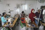 Pekerja membuat baju 'koko' atau baju muslim di sebuah industri baju 'koko' rumahan di kawasan Bulak Banteng, Surabaya, Jawa Timur, Jumat (2/6). Produksi baju 'koko' di tempat tersebut meningkat 100 persen di bulan Ramadan. Antara Jatim/Didik Suhartono/zk17 