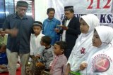 Ketua Komunitas Koperasi Syariah 212 Bogor-1, Ir Bambang Mohamad Subur MM (baju biru tua) saat memberikan bingkisan kepada anak-anak yang hadir pada peresmian perdana '212 Mart' wilayah Bogor Barat. (FOTO ANTARA/Humas '212 Mart'). 