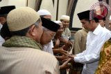 Presiden Joko Widodo saat berjabat tangan dengan para jemaah usai melaksanakan Shalat Tarawih berjamaah bersama warga di Masjid Al Muslimun, Jl. Indraprasta, Kota Bogor, Jawa Barat, Kamis malam (1/6/17). (Foto Antara/Kris-Biro Pers Setpres/Dok).