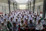 Menteri Hukum dan HAM, Yasonna Hamonangan Laoly (depan bertopi) duduk bersama para santri Pondok Pesantren At Taubah di Lapas Kelas I Lowokwaru, Malang, Jawa Timur, Senin (5/6). Pondok pesantren tersebut sengaja didirikan sebagai upaya pembelajaran, kajian religius serta upaya penyadaran bagi sekitar 400 santri yang merupakan narapidana. Antara Jatim/Ari Bowo Sucipto/zk/17.