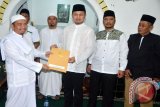 Wali Kota Bogor Jawa Barat Bima Arya Sugiarto (tengah) saat memberikan bantuan untuk perbaikan Masjid pada kegiatan Tarawih Keliling (Tarling) Ramadhan 1438 H/2017 M, di Masjid Jami Nurul Huda, Kelurahan Sukasari, Kecamatan Bogor Timur. Bantuan Rp15 juta itu diterima oleh Ketua Dewan Kemakmuran Masjid (DKM) setempat, H Saiful Bahri. (ANTARA FOTO/M.Tohamaksun).