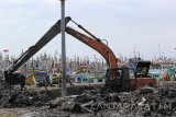  Alat berat melakukan pengerukan dermaga di Pelabuhan Ikan Muncar, Banyuwangi, Jawa Timur, Jumat (9/6).  Pengerukan dermaga tersebut untuk mengurangi sedimentasi yang menghambat lalulintas kapal yang akan sandar. Antara Jatim/Budi Candra Setya/zk/17. 