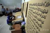  Seorang warga binaan bernama Ahmad Yani menulis mushaf (lembaran) Alquran raksasa di Lapas Klas IIB Blitar, Jawa Timur, Selasa (13/6). Kitab suci Alquran yang memiliki ukuran halaman 90 x 120 centimeter dengan tulisan tangan tersebut, ditargetkan rampung pada lima bulan mendatang. Antara Jatim/Irfan Anshori/zk/17 
